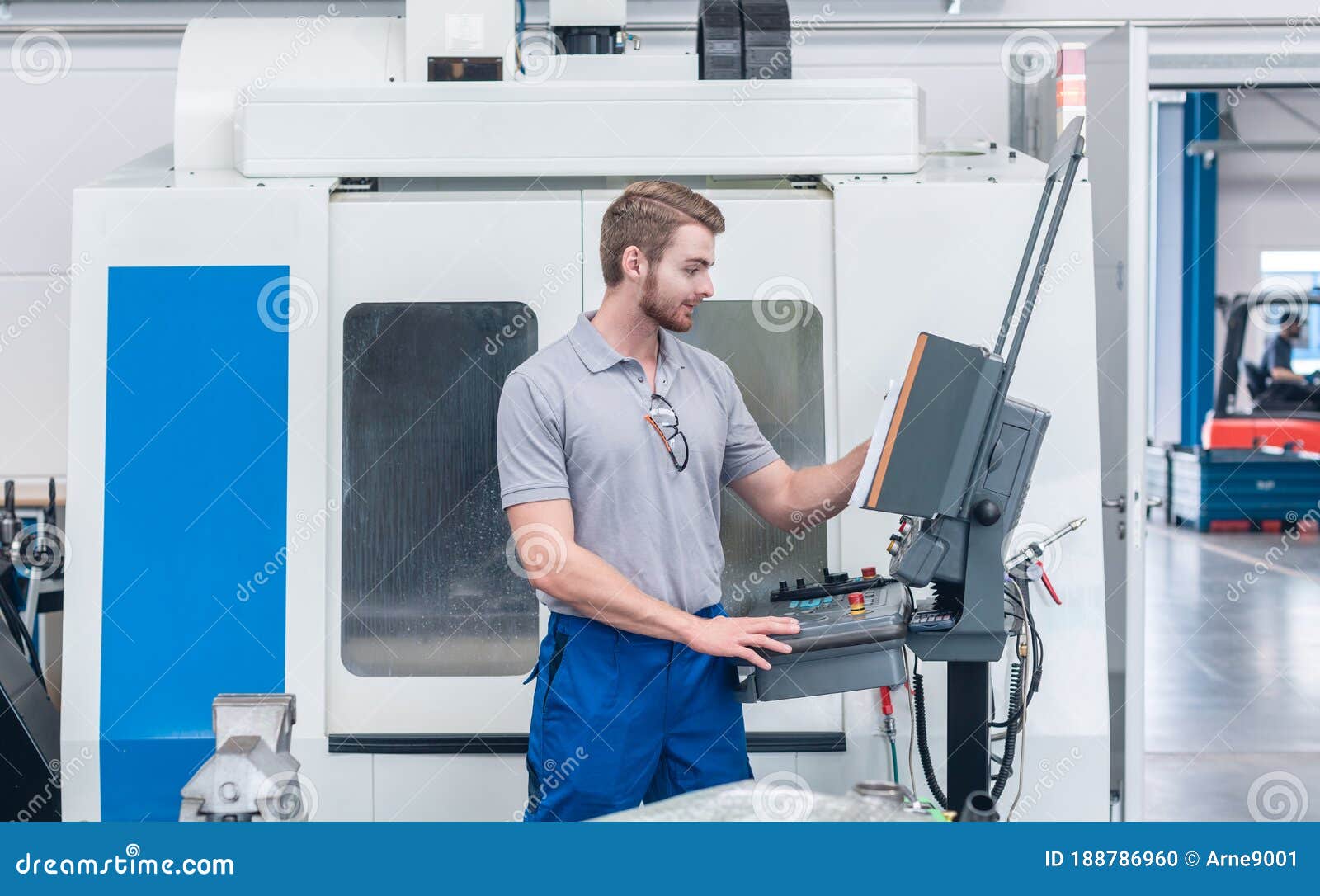 worker operating computer-controlled machine tool