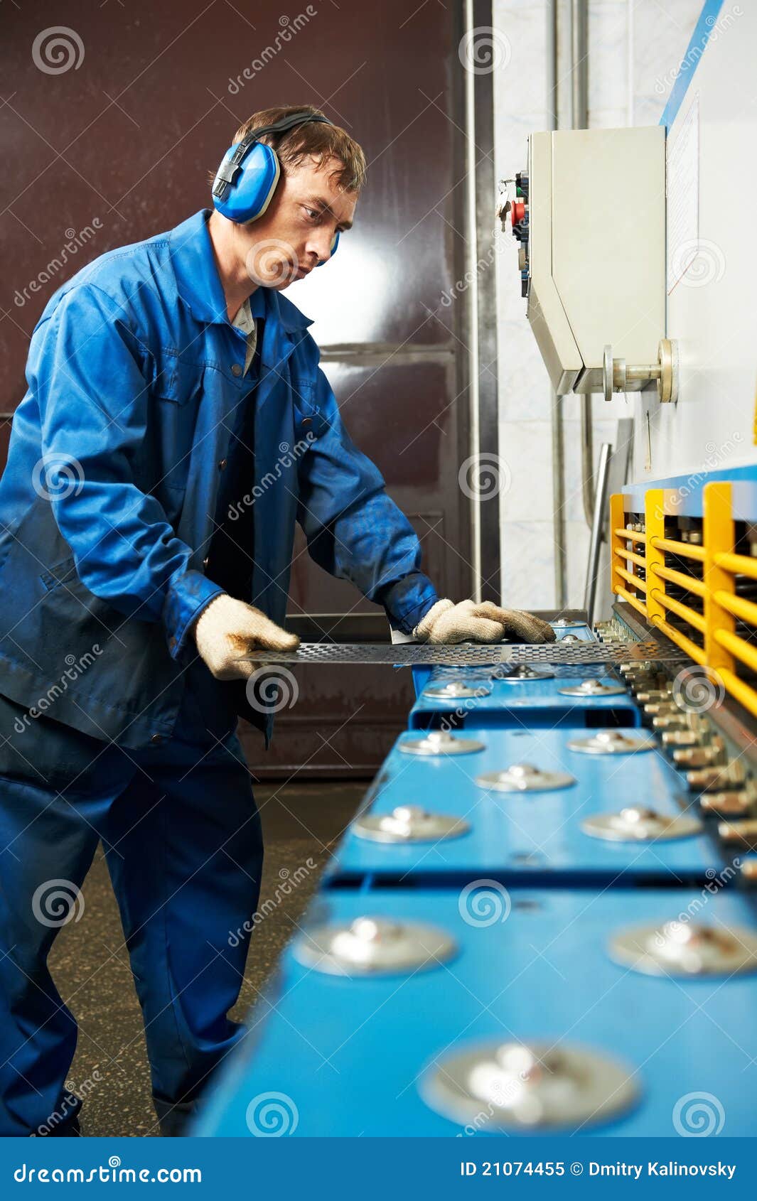worker operating guillotine shears machine
