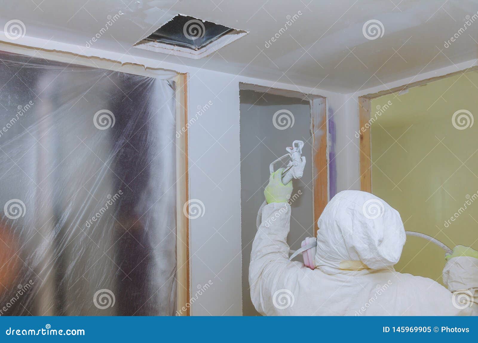 Worker Painting Wall With Spray Gun In White Color Stock Image