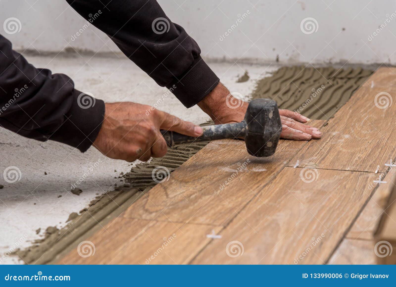 Worker Placing Ceramic Floor Tiles On Adhesive Surface Leveling