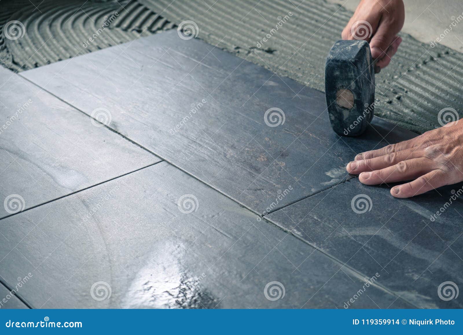 Worker Placing Ceramic Floor Tiles on Adhesive Surface Stock Photo