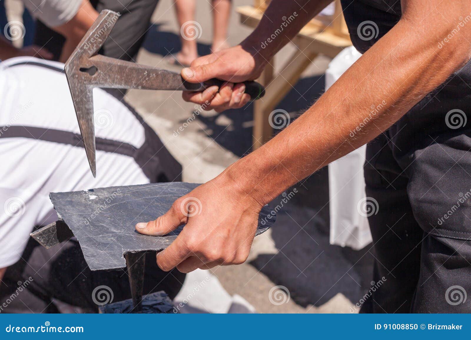 Worker Produces Roofing Slate Using a Slate Hammer. Stock Photo Image