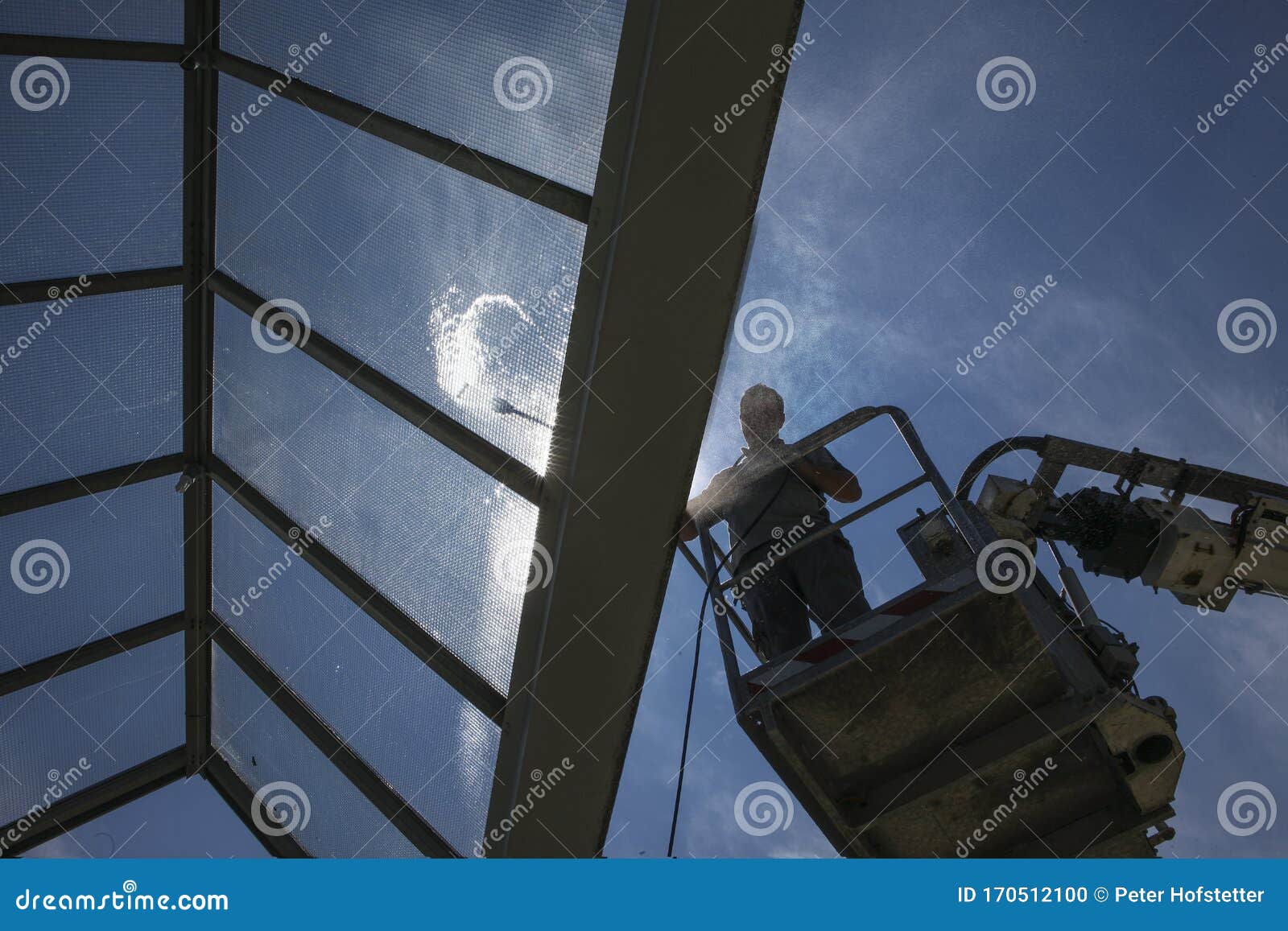 worker of professional facade cleaning services washing a glass