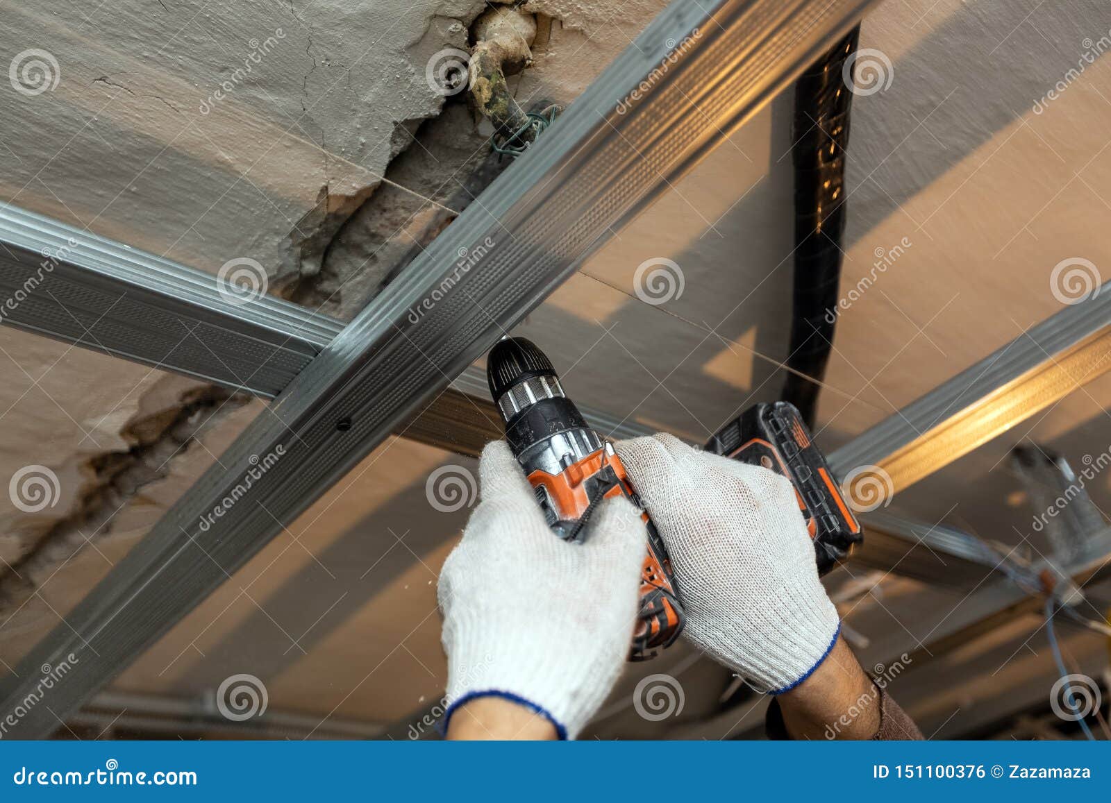 Worker with Protective Gloves is Drilling by Perforator the Ceiling for