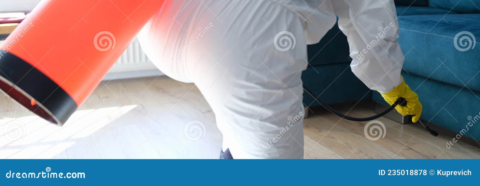 Worker in Protective Suit Treating with Disinfectant Solution on Floor