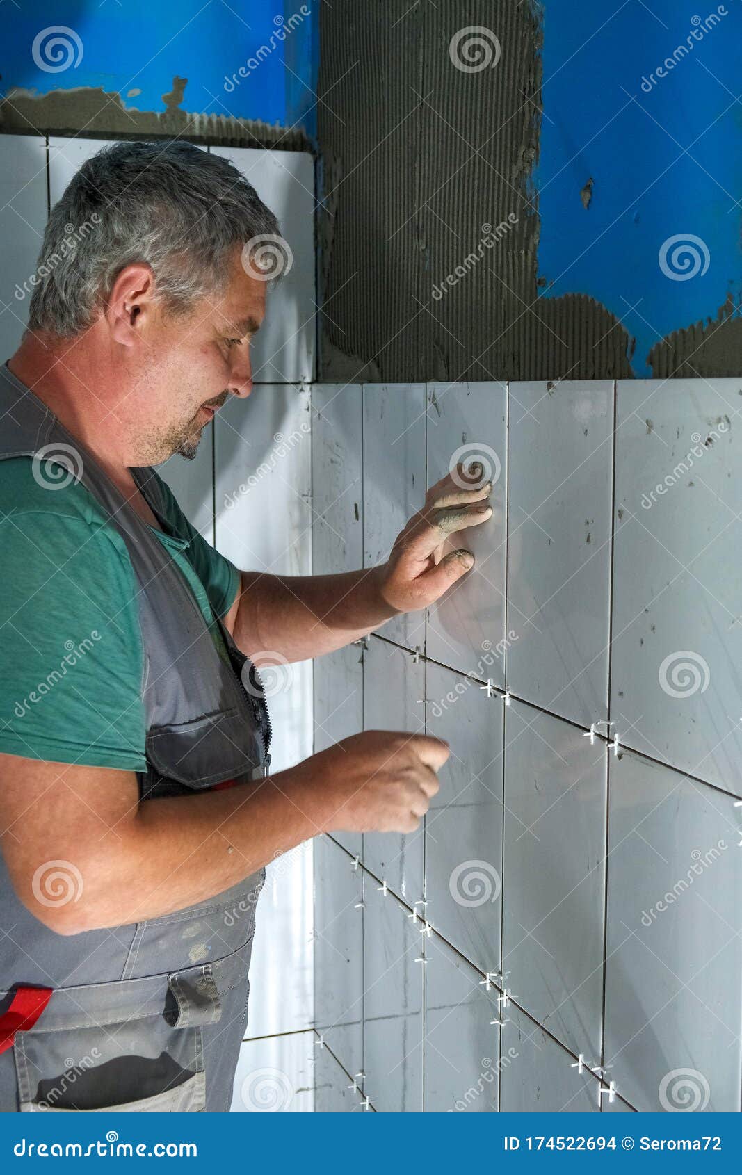 The Worker Puts Ceramic Tiles on the Construction Site Stock Photo