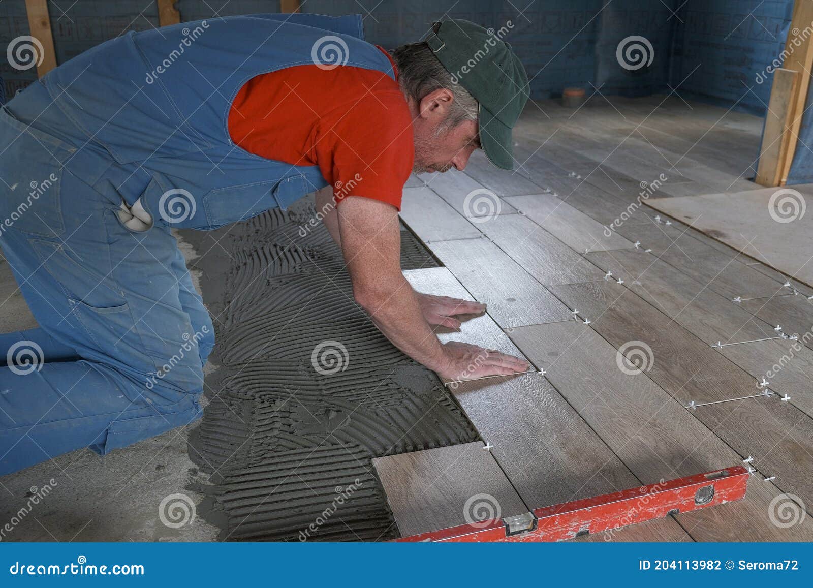 The Worker Puts Ceramic Tiles on the Construction Site Stock Photo