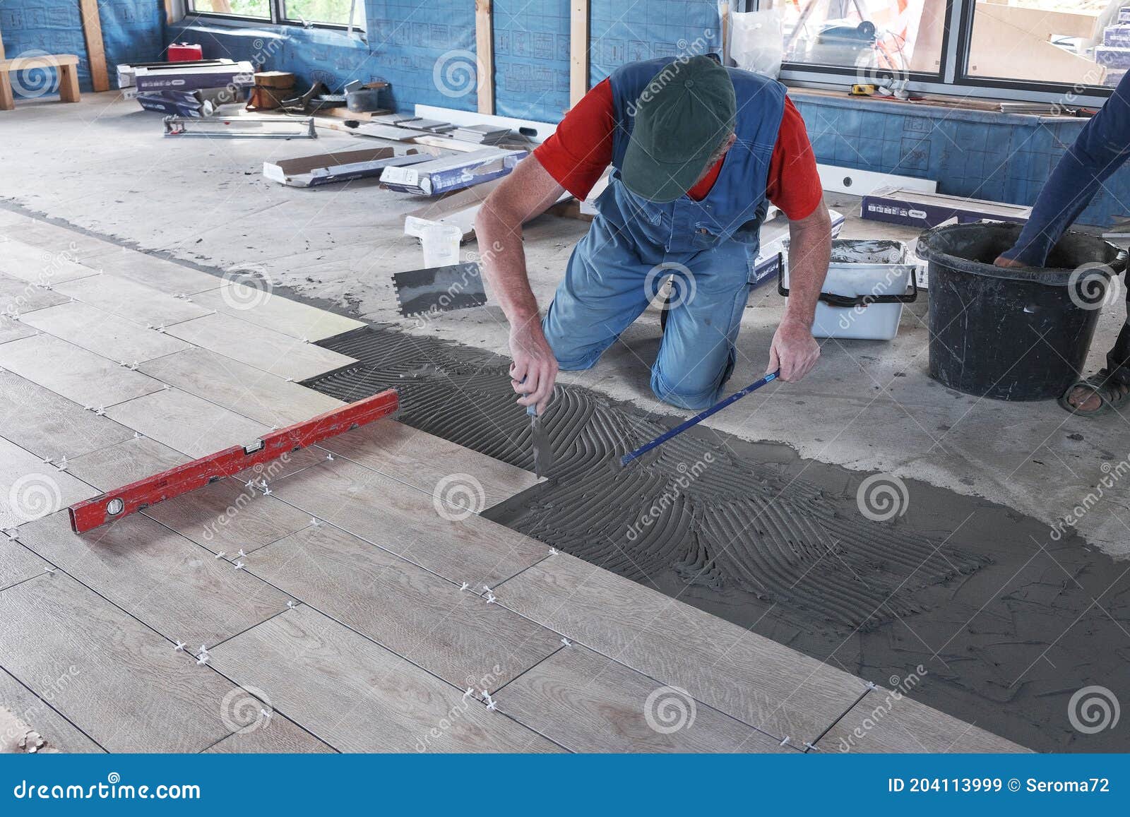 The Worker Puts Ceramic Tiles on the Construction Site Stock Image