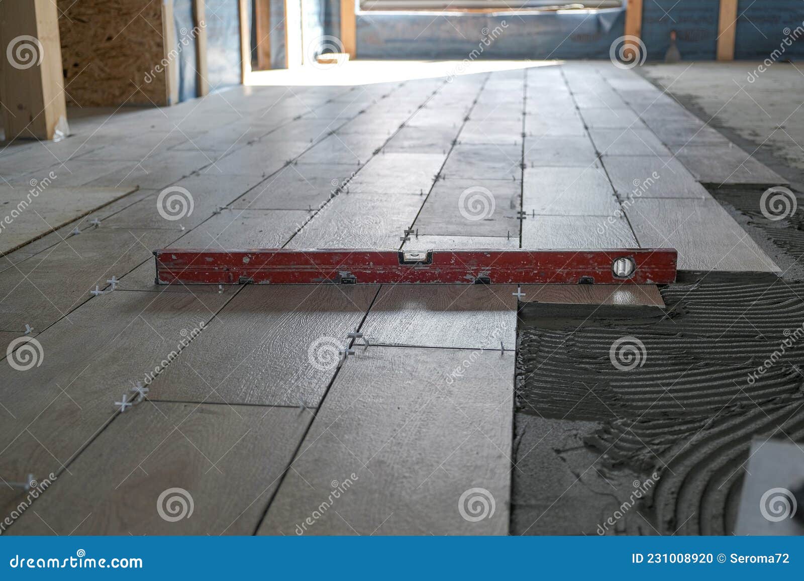 The Worker Puts Ceramic Tiles on the Construction Site Stock Photo