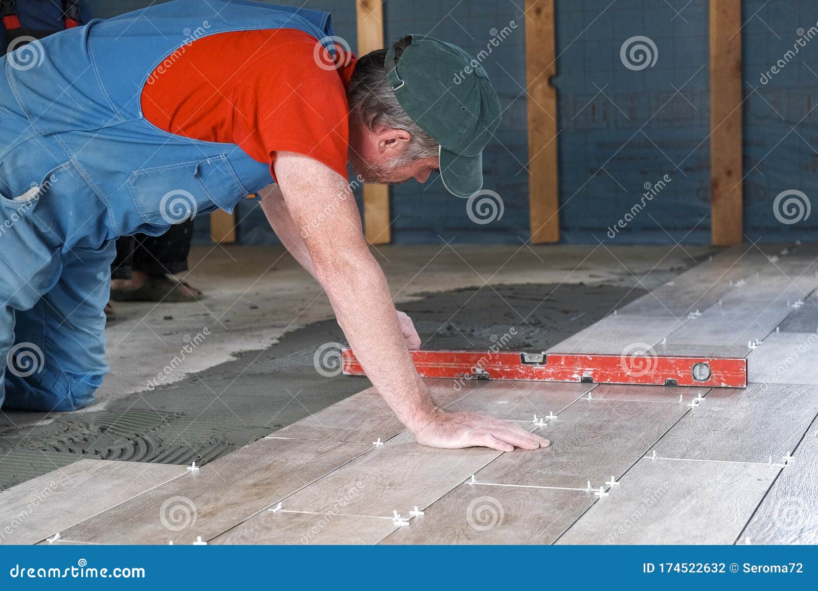 The Worker Puts Ceramic Tiles on the Construction Site Stock Photo