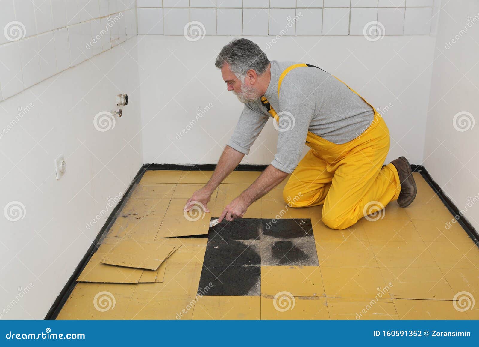 Old Vinyl Tiles Removal From Floor In A Kitchen Stock Photo