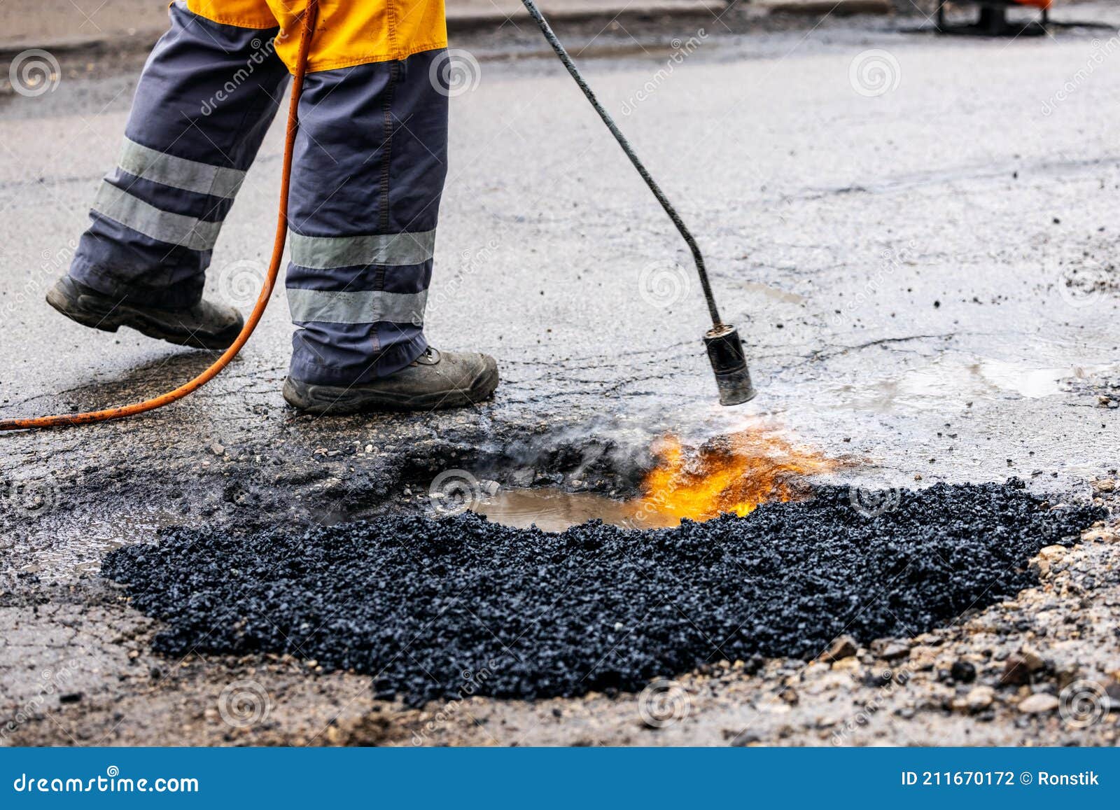 Worker Repairing Pothole With Bitumen Asphalt On The Road Stock Photo worker-repairing-pothole-with-bitumen-asphalt-on-the-road-stock-photo
