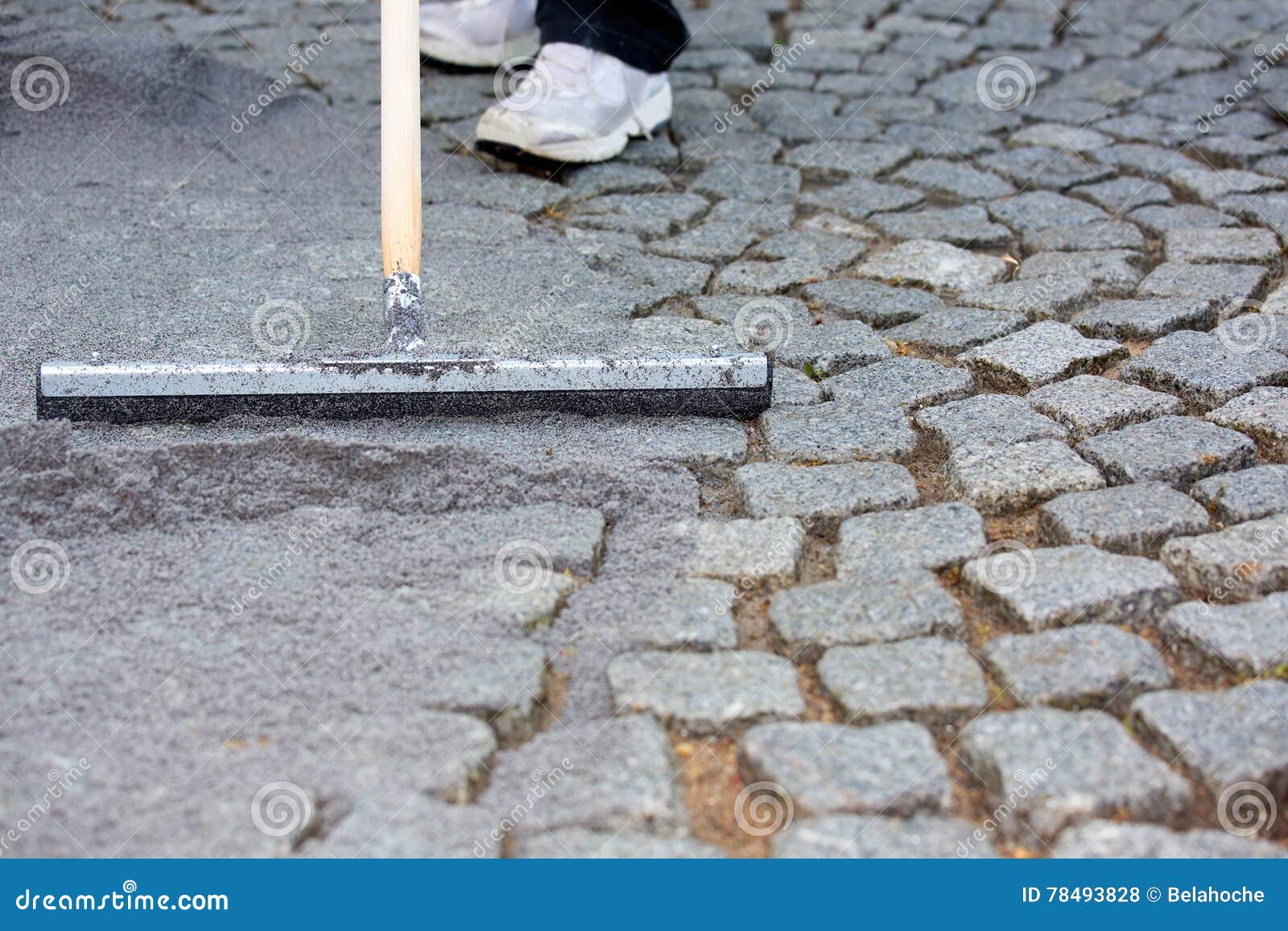 worker resurfacing cobblestones