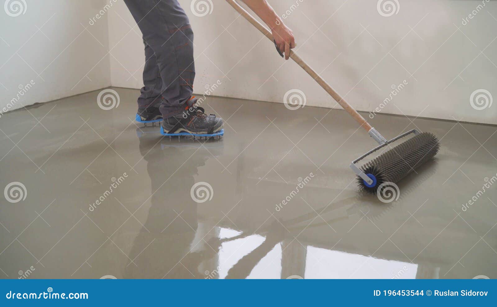 A Worker Rolls Out the Liquid Floor with a Trowel. Squeegee for