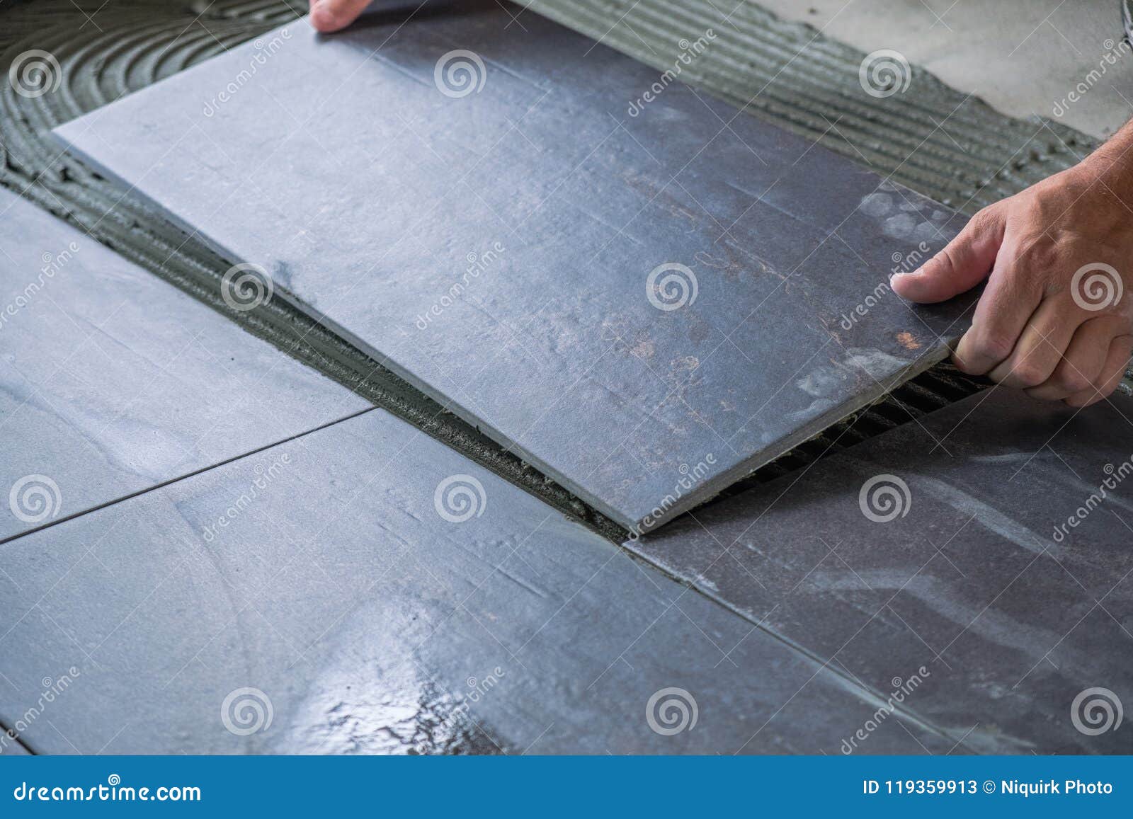 Worker Placing Ceramic Floor Tiles on Adhesive Surface Stock Image