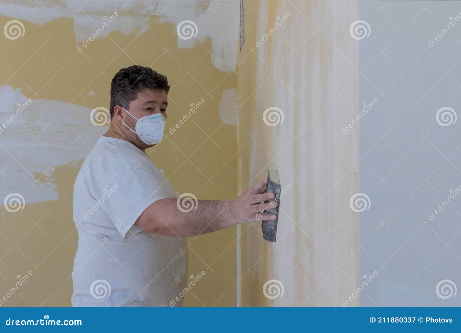 Worker Sanding the Drywall Mud Using Sand Trowel during Renovation the