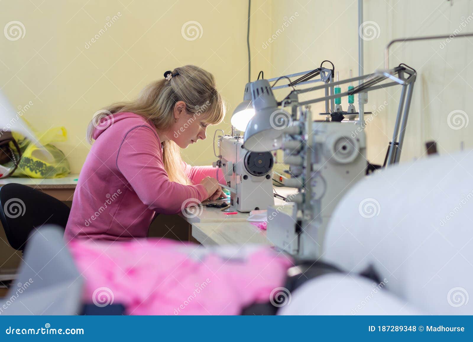 Worker in Sewing Sews on a Professional Sewing Machine Stock