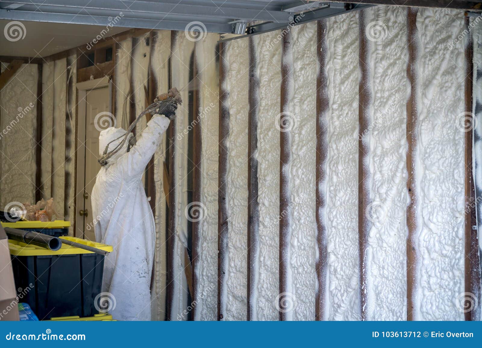 worker spraying closed cell spray foam insulation on a home wall