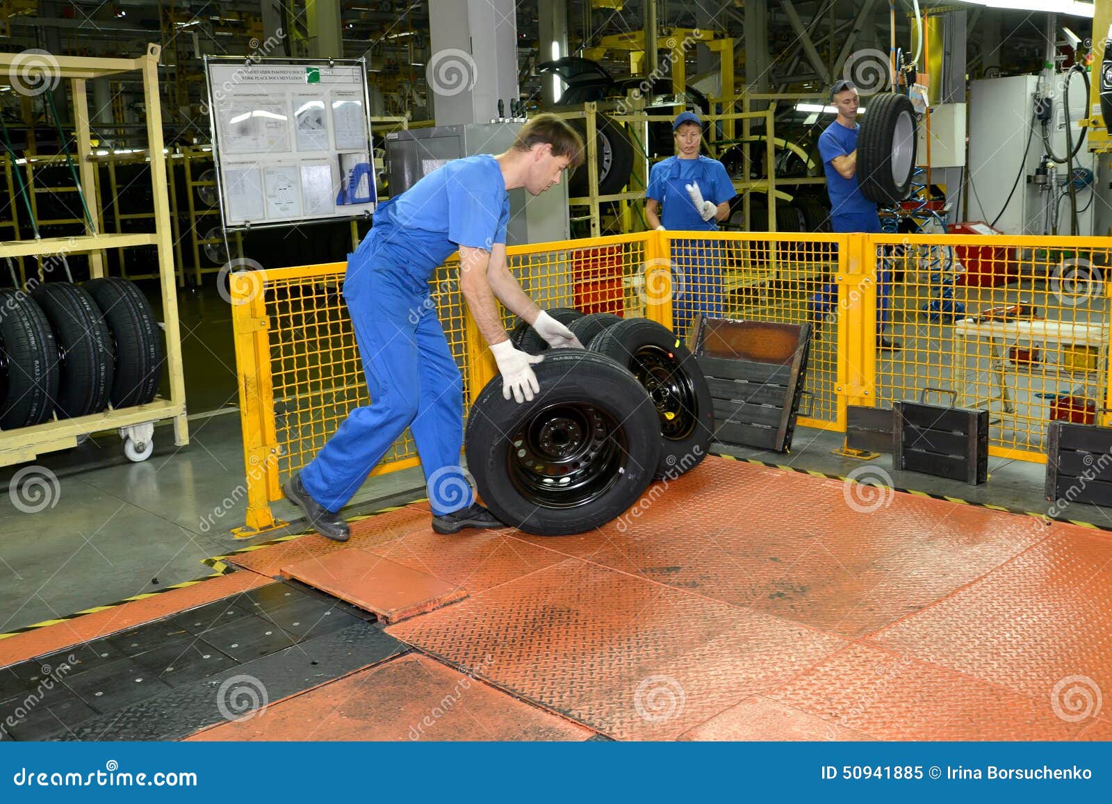 The Worker Stores Automobile Wheels in Assembly Shop. Automobile
