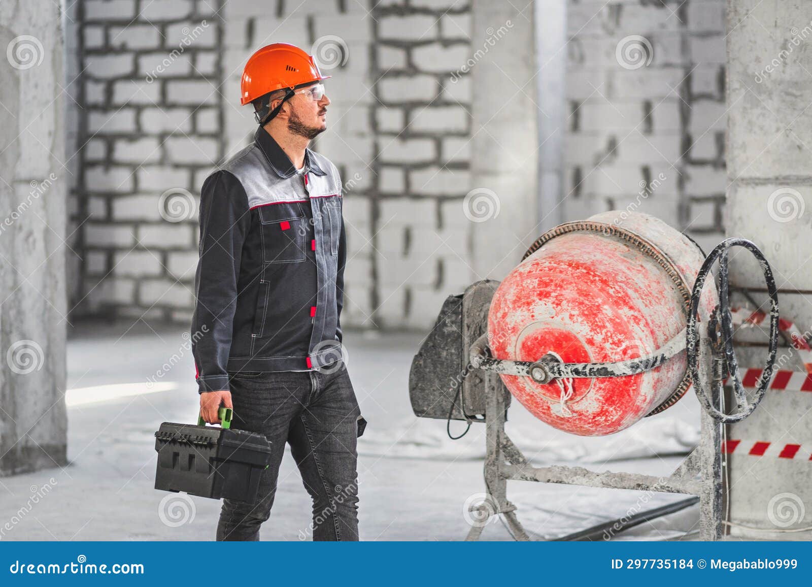 A Worker with a Suitcase with Tools, in Overalls, Walks Along a