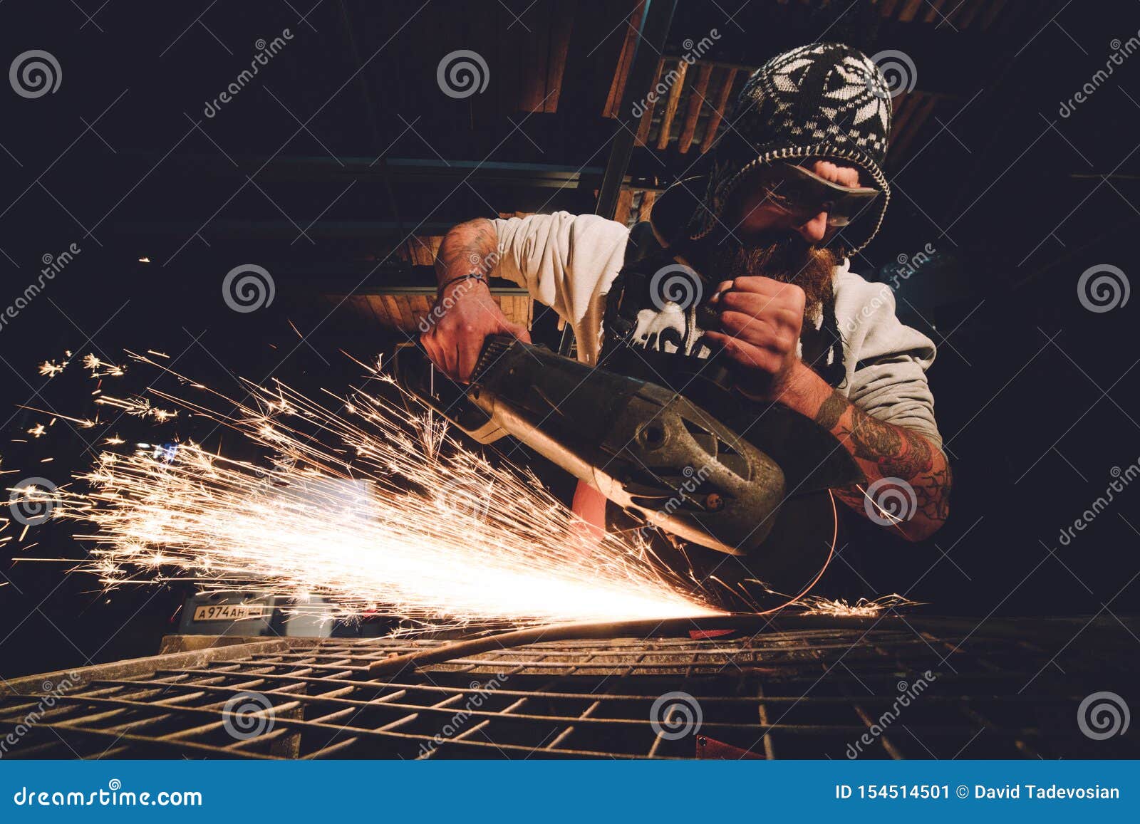Worker Using Angle Grinder in Factory and Throwing Sparks. Stock Image