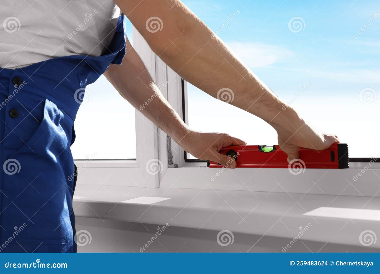 Worker Using Bubble Level after Plastic Window Installation Indoors