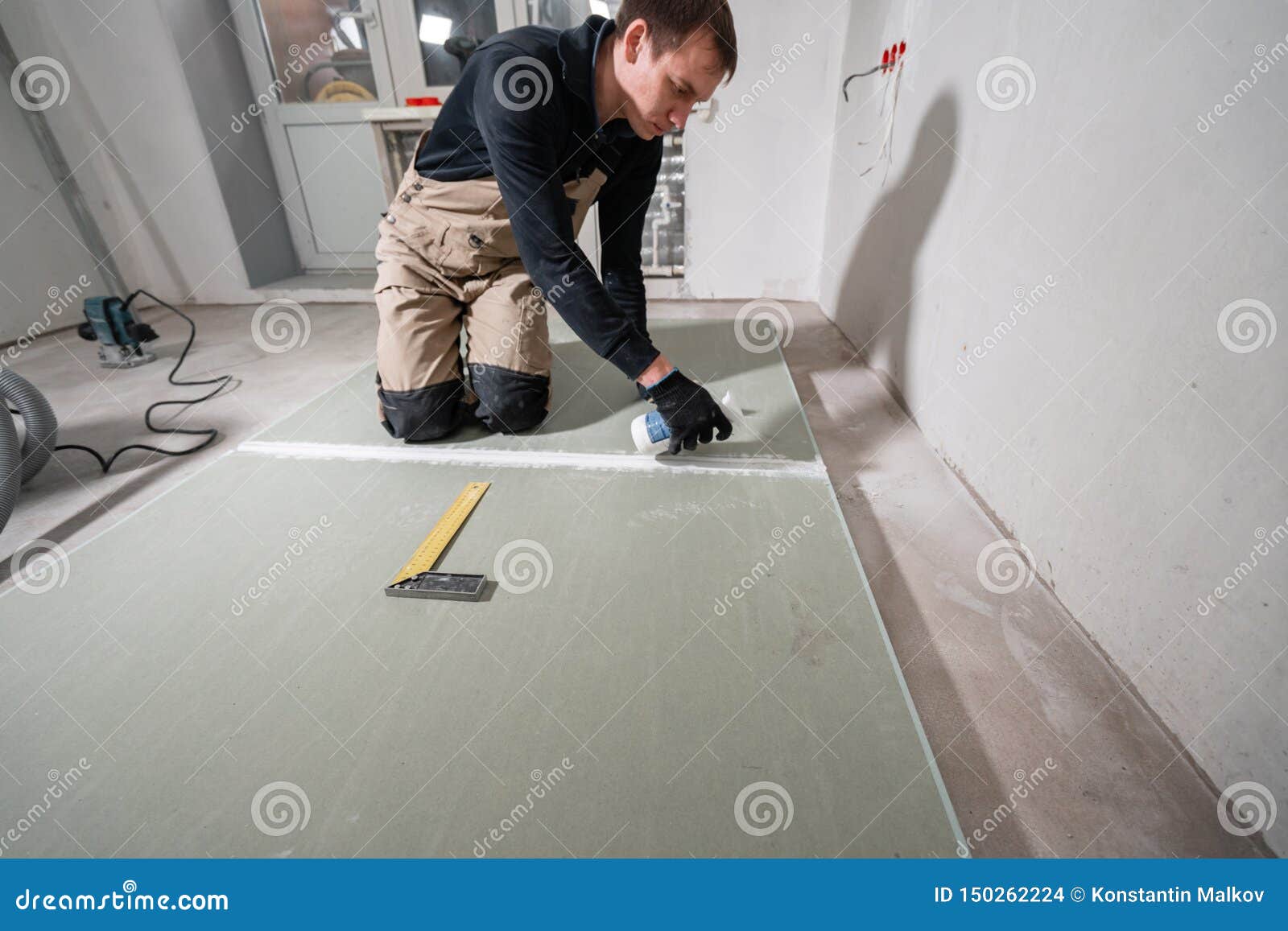Worker is Using a Polyurethane Foam for Gluing Drywall at