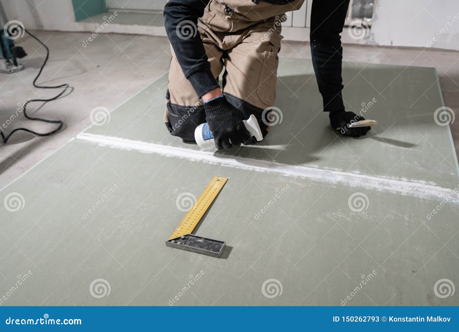 Worker is Using a Polyurethane Foam for Gluing Drywall at