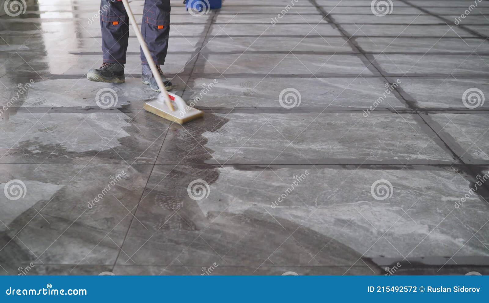 Worker Washing Tiles after Work. a Worker Washes the Tiles on the Floor