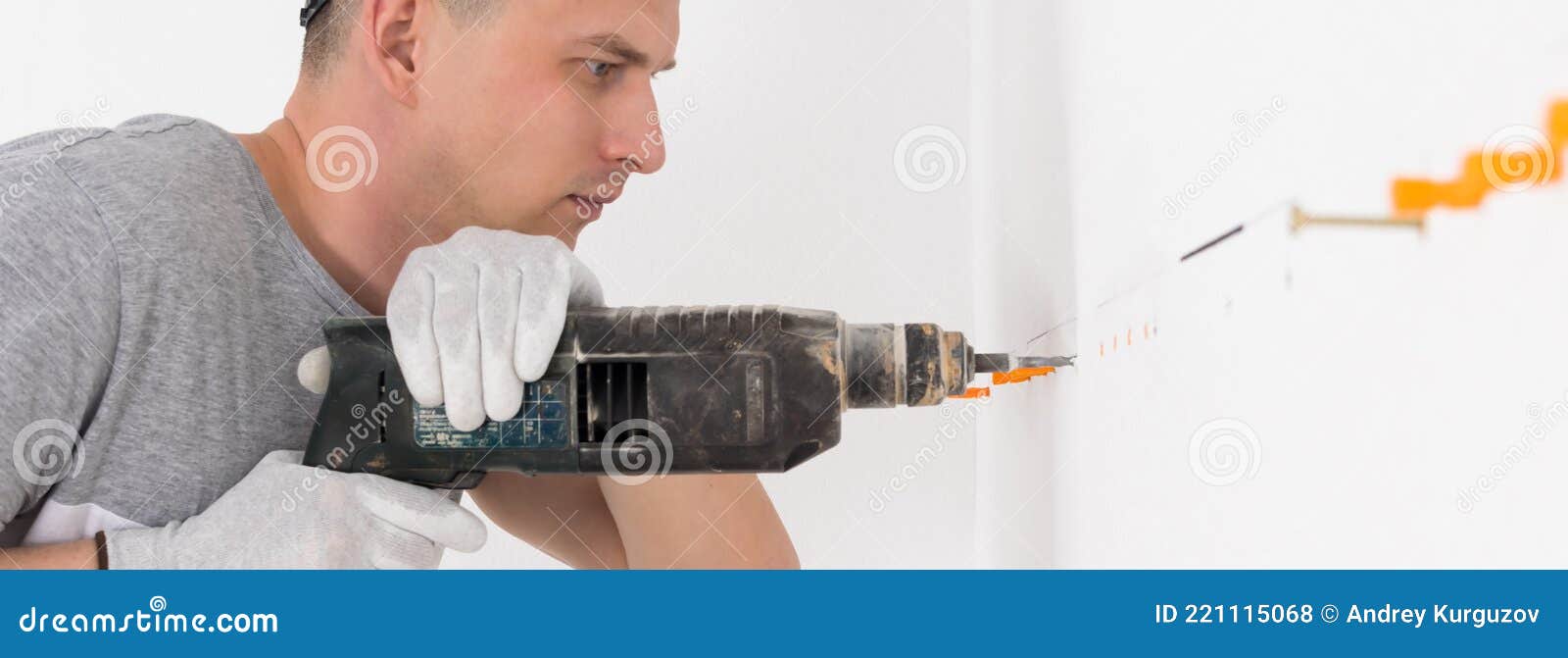 A Worker Works with a Puncher, Makes Holes in the Wall, Long Photo