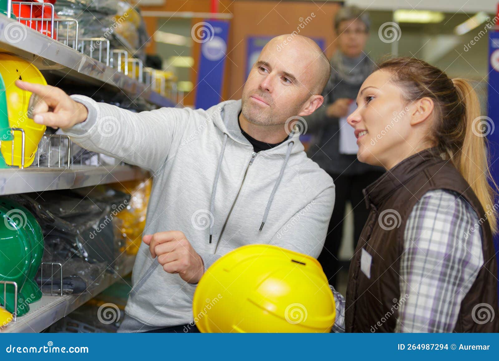 Workers Choosing Construction Helmets in Hardware Store Stock Photo