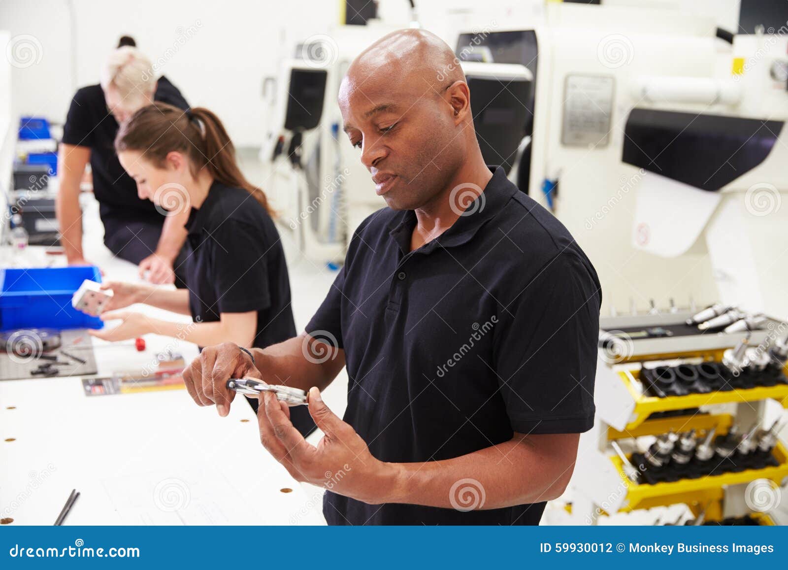 workers in engineering factory checking component quality