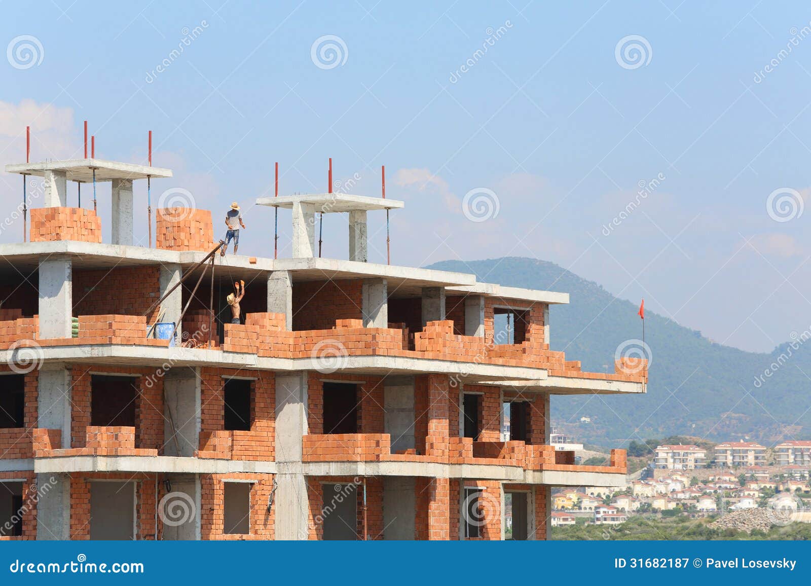 workers erect balconies from brick in new building