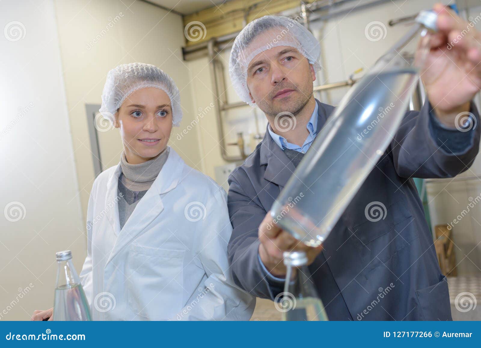 Workers in Factory Checking Water Bottles before Shipmen Stock Photo