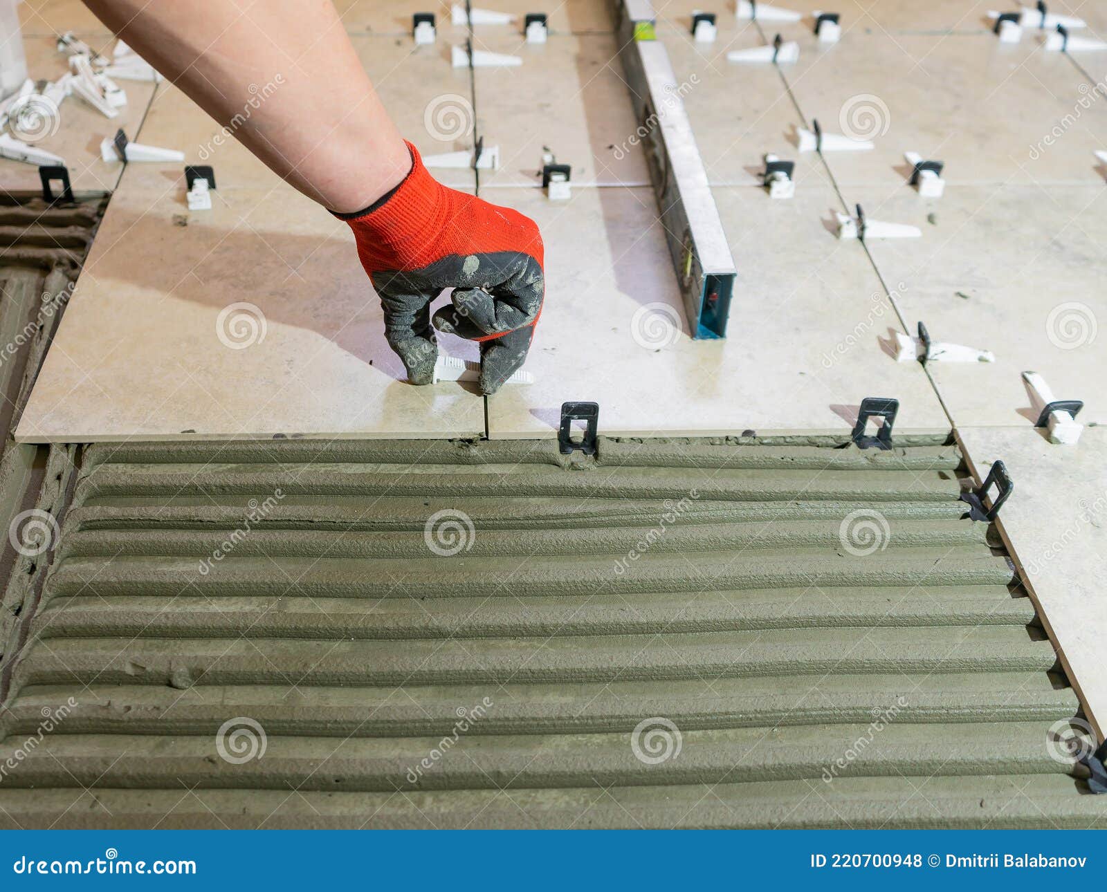 Workers Hands with Ceramic Tiles and Tools for Tiler. Floor Tiles
