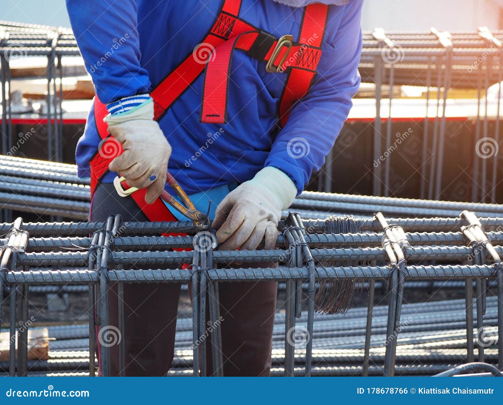 workers hands using steel wire and pincers to secure rebar