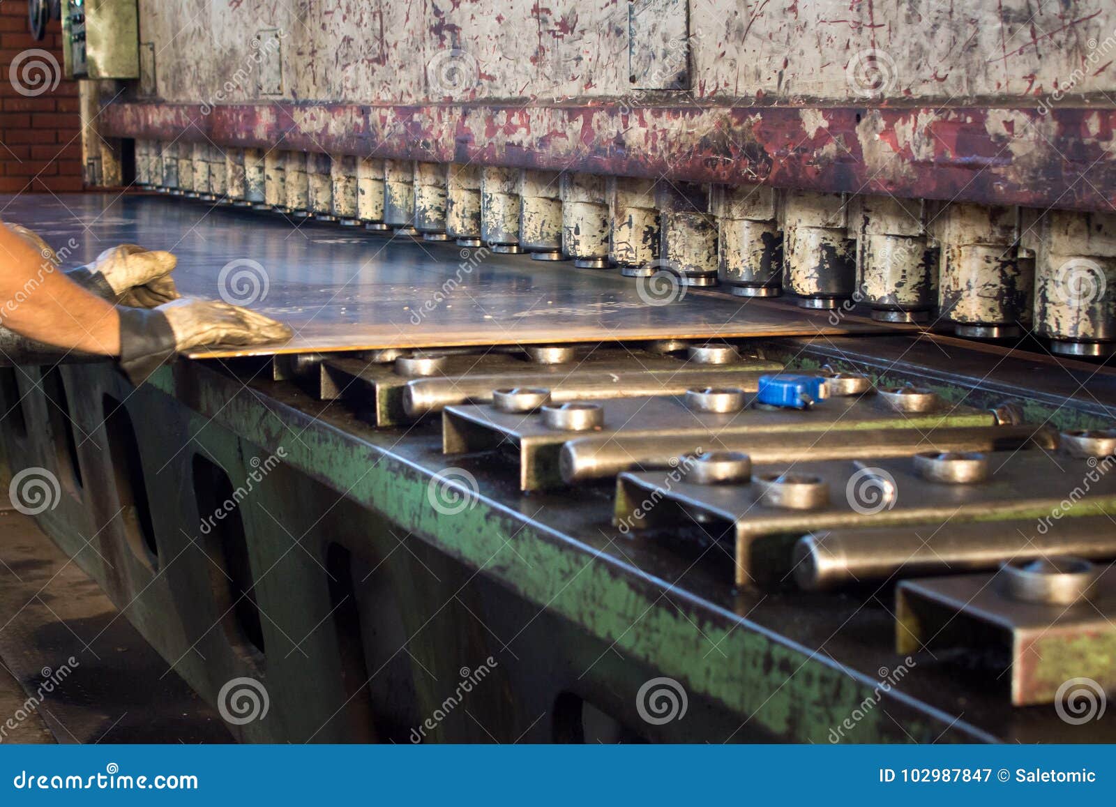 Workers Inserting Metal Plate into Compression Machine Stock Image