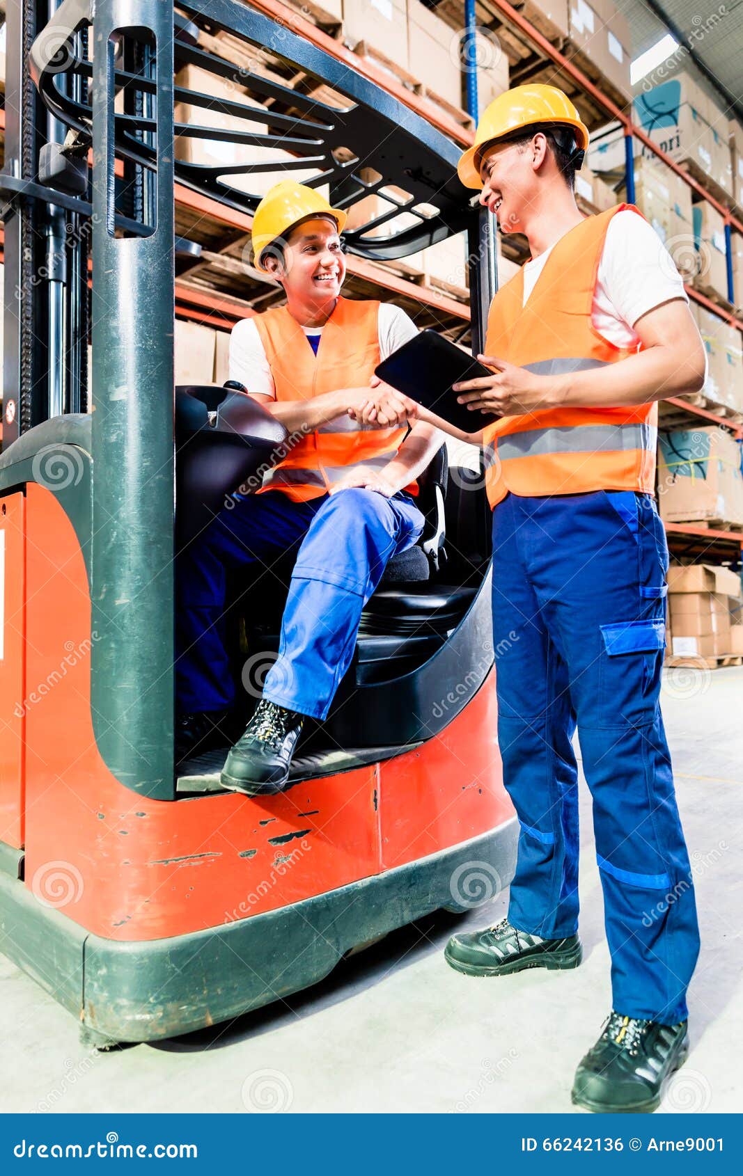 workers-in-logistics-warehouse-at-forklift-checking-list-stock-photo