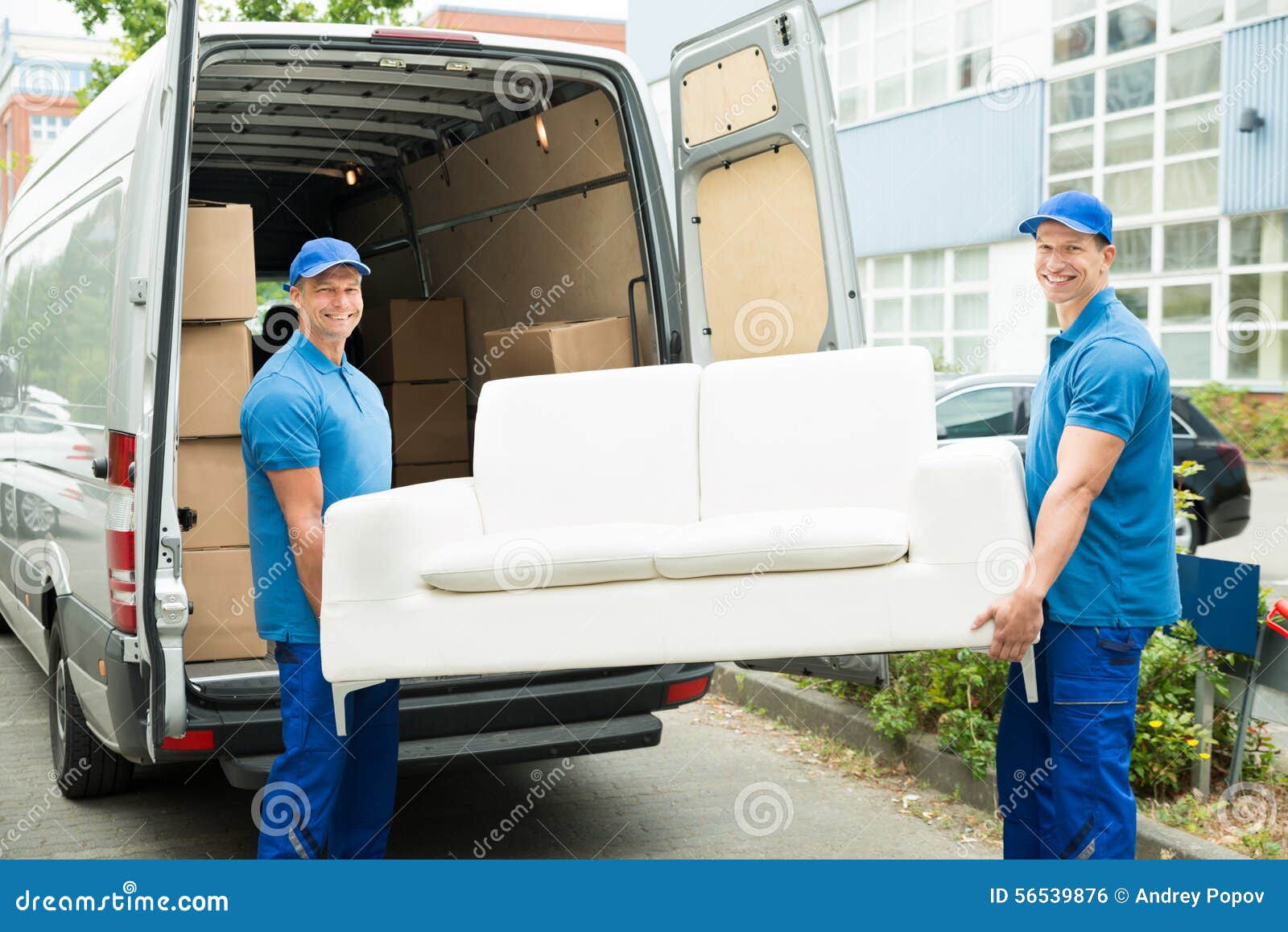 workers putting furniture and boxes in truck