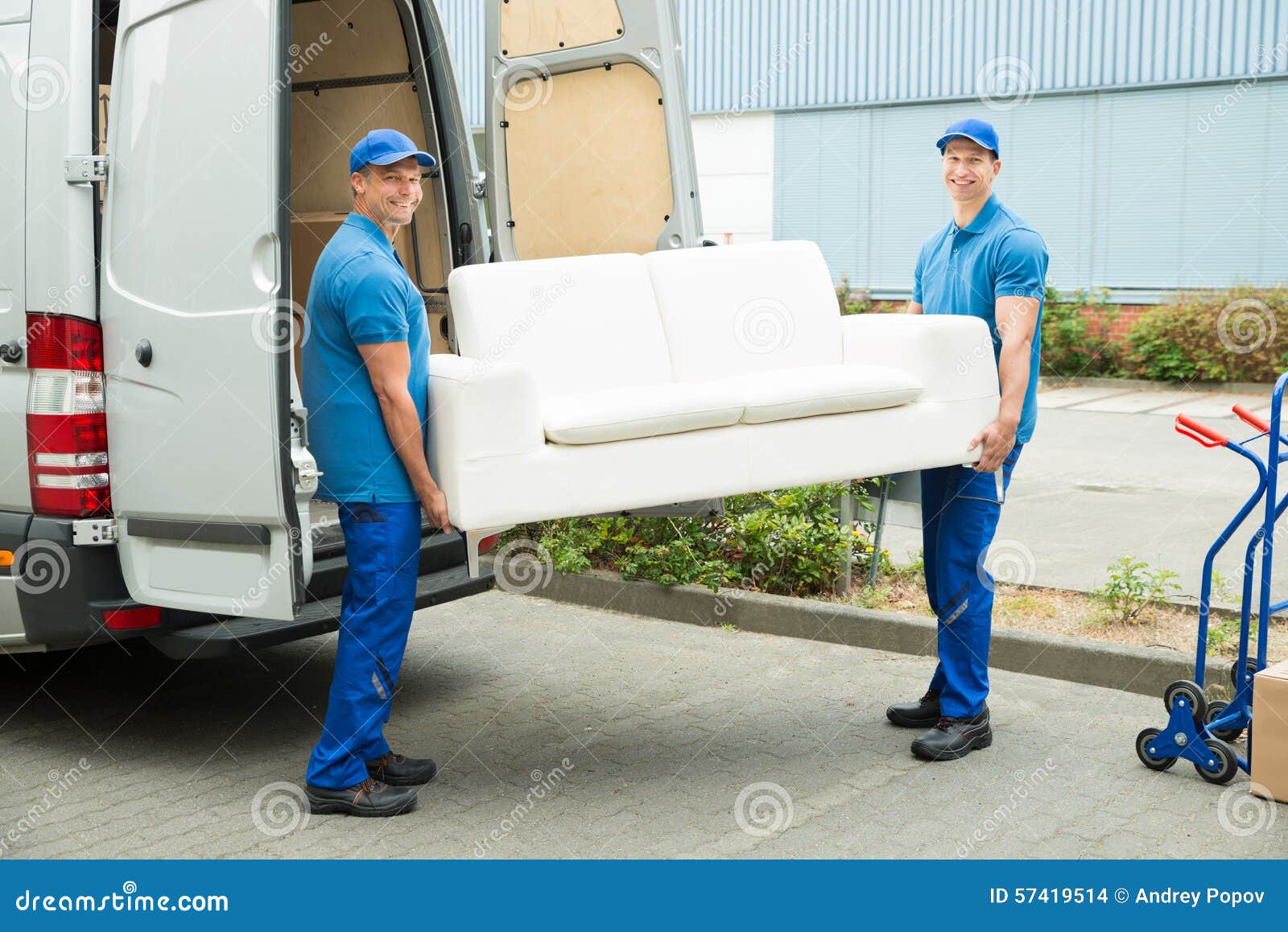 workers putting furniture and boxes in truck
