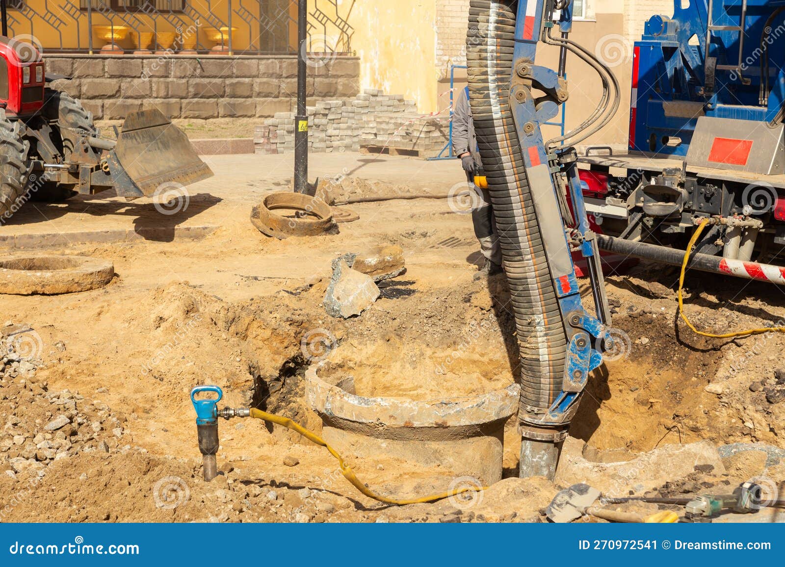 workers use a suction excavator based on a truck to sample soil in a well for communications