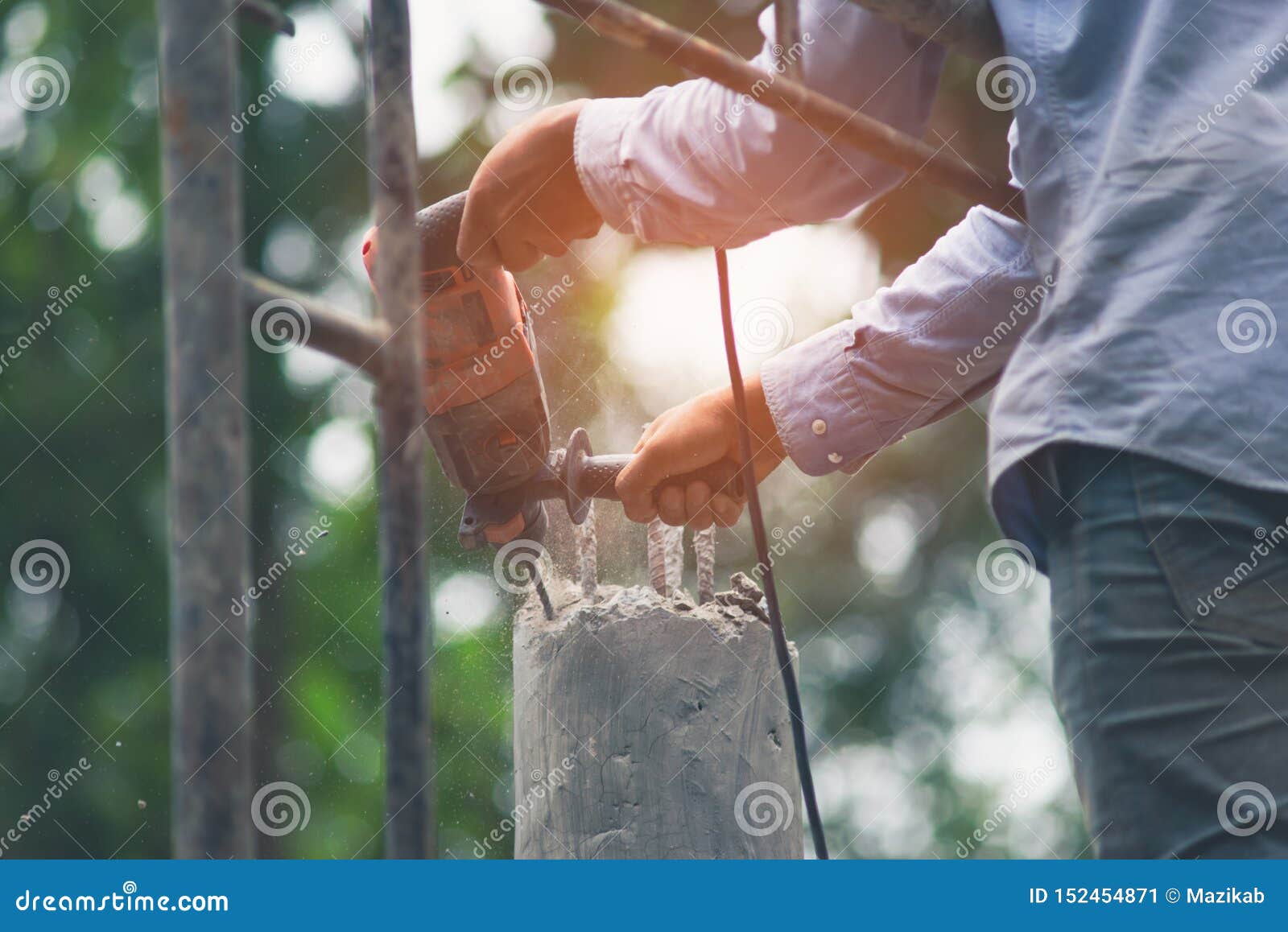 Workers are Using Impact Drill To Drill Concrete. Under Sunlight Stock