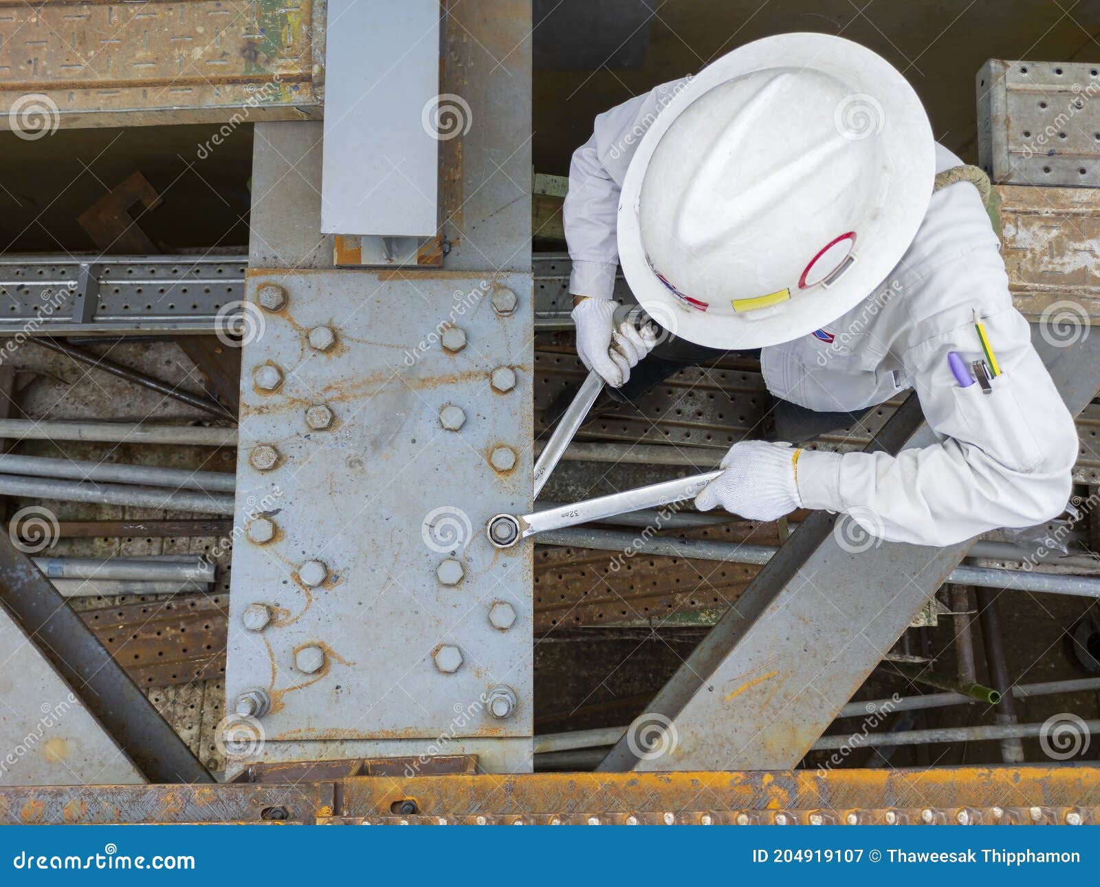 Workers are Using a Wrench To Torque Bolts To Hold the Splice Plate To