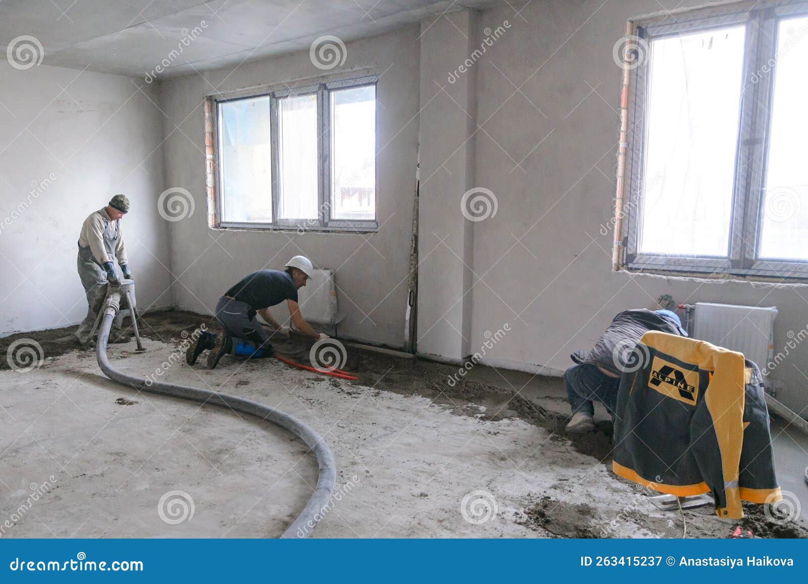 Workers in Work Clothes are Doing Their Job, Leveling the Floor and