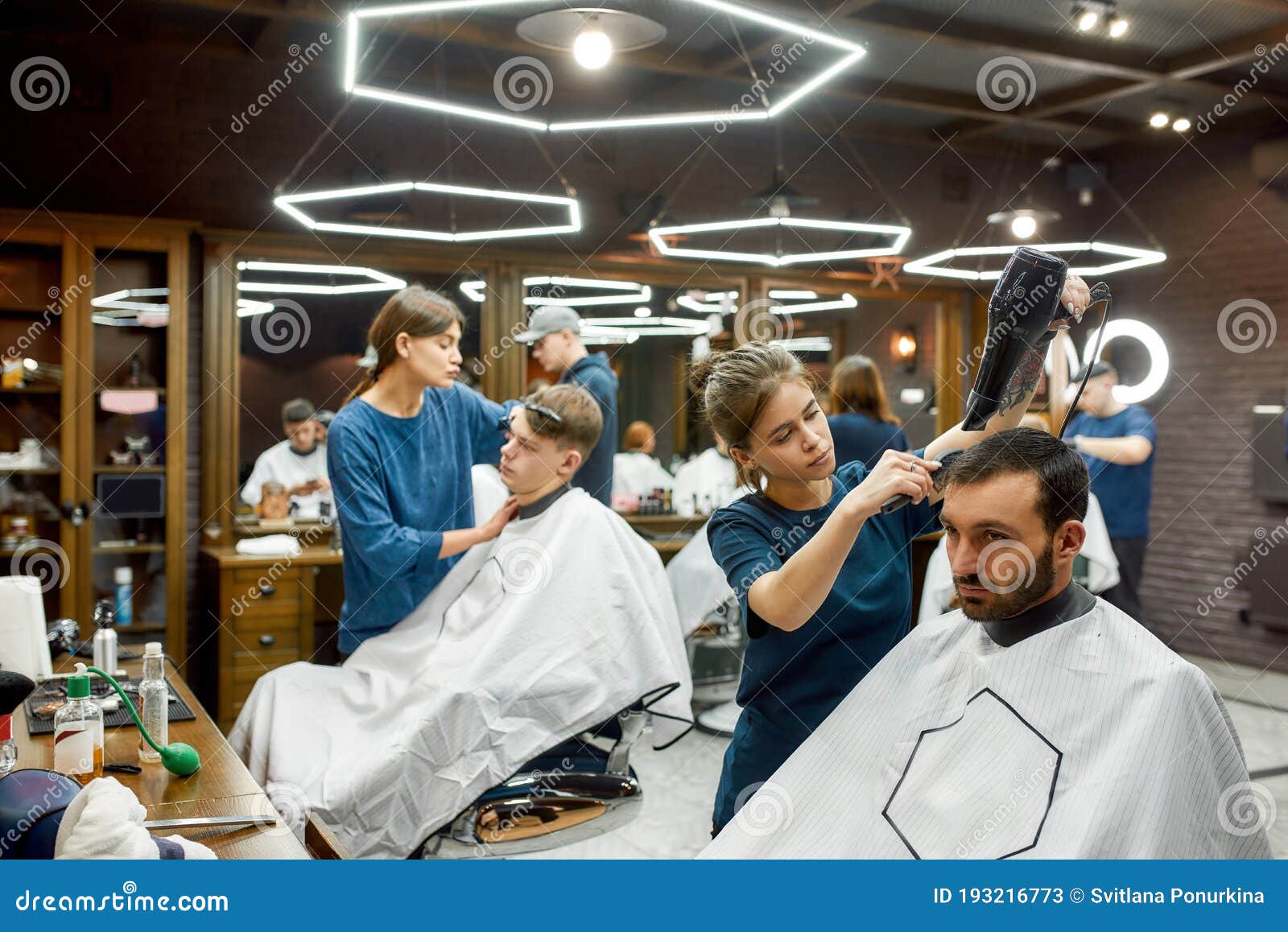 Working in Barbershop Professional Young Barber Girl Drying Hair of Working in Barbershop Professional Young Barber Girl Drying Hair of