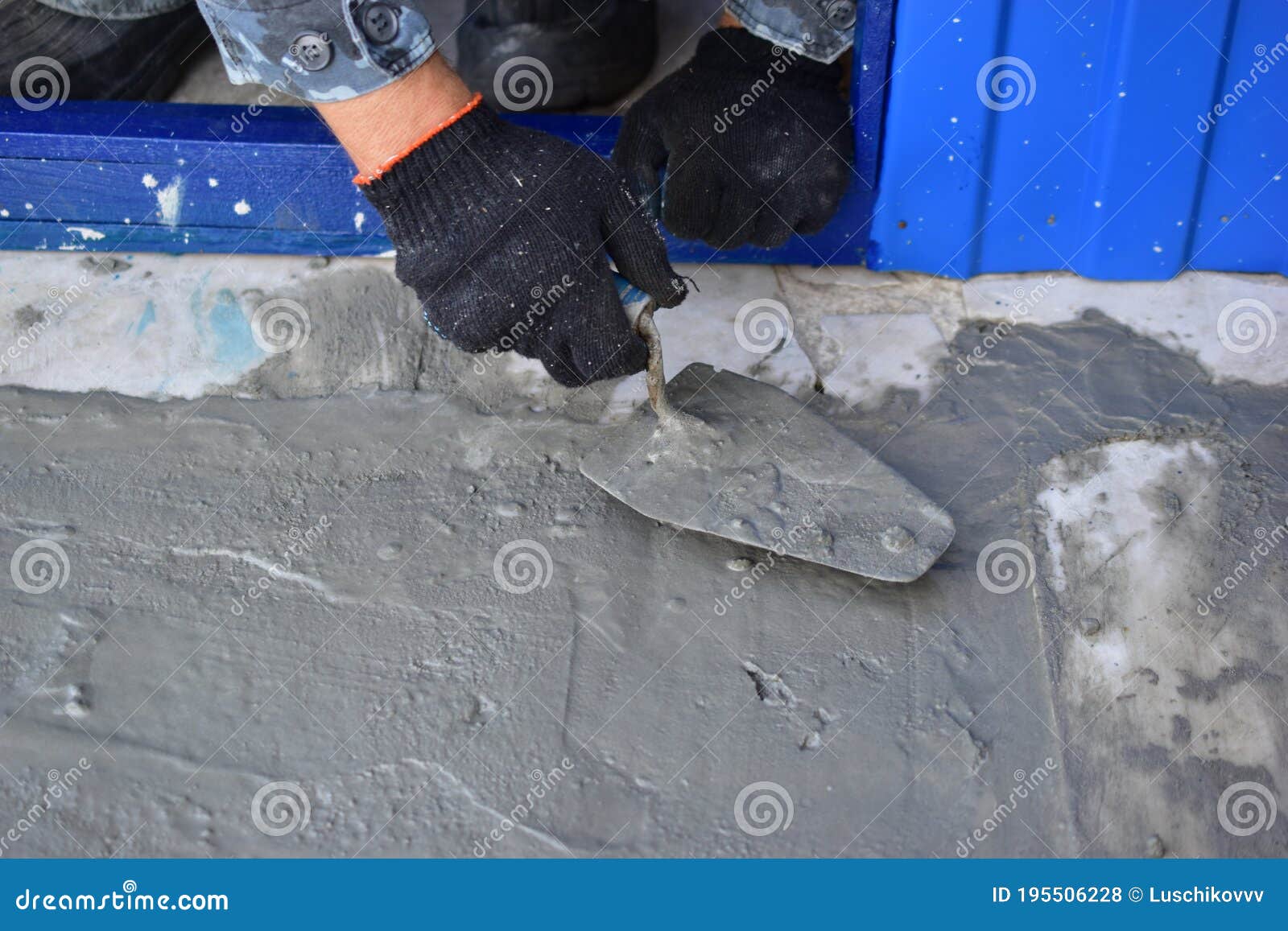 Working on Concrete with a Trowel Leveling the Surface Stock Photo