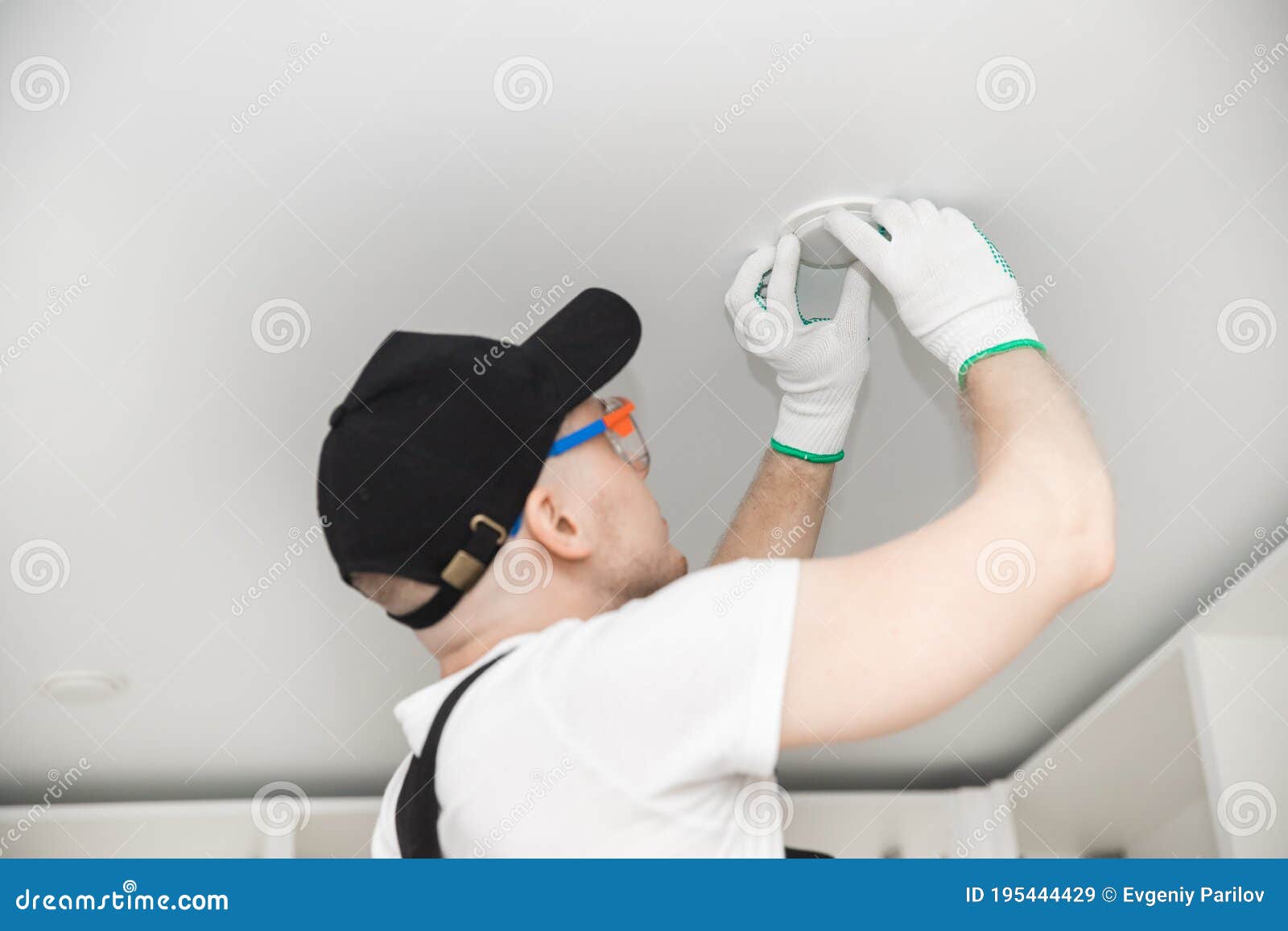 Working Electrician Changes Light Bulb and Installs Wiring for Lamp in