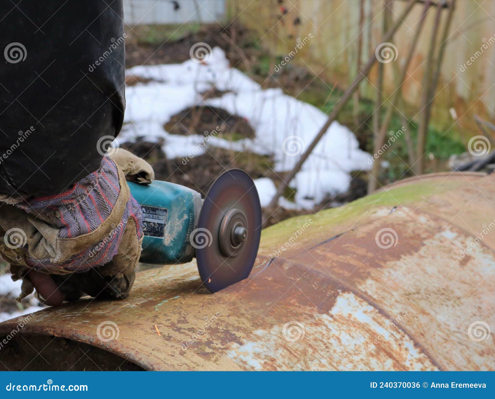 Cutting a Rusty Metal Barrel with a Grinder Stock Photo Image of