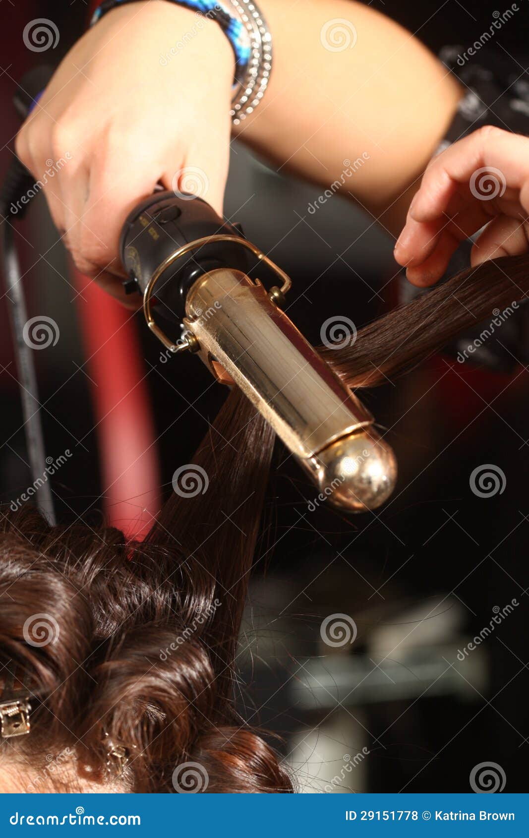 working hairstylist curling hair in a salon