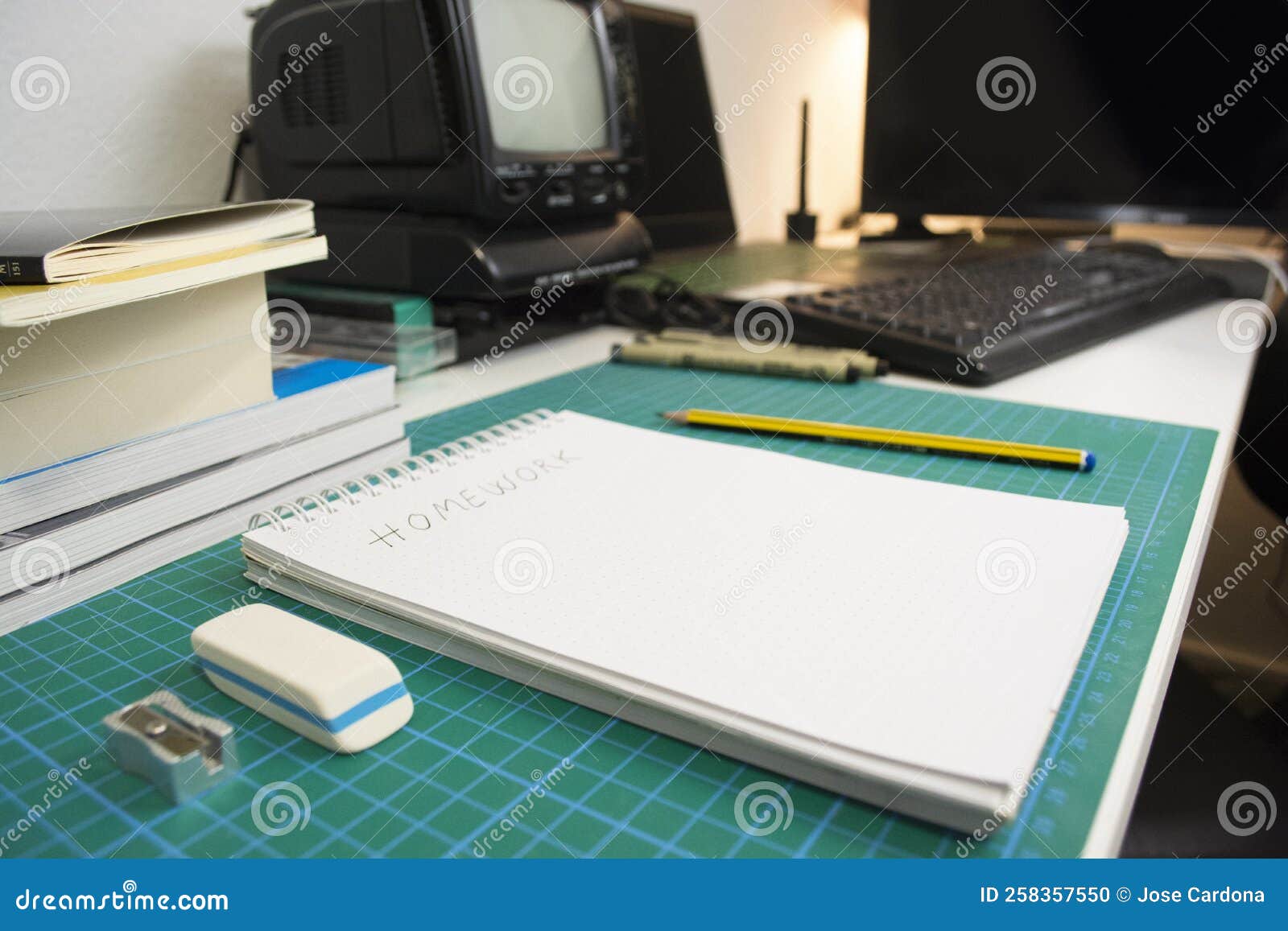 working place of student with books, notebooks, old tv and laptop